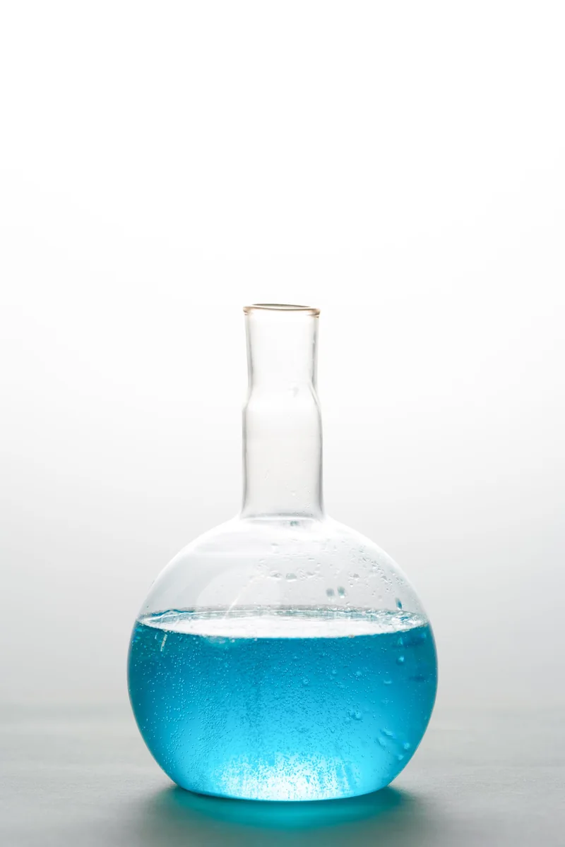 Blue liquid in laboratory glassware, illustrative imagery for industrial chemicals